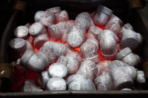 Silver metal ingots or billets glowing with red heat inside a furnace, ready for forging or processing, evoke the intense energy found in pulp and paper mills where raw materials are transformed by heat and pressure.
