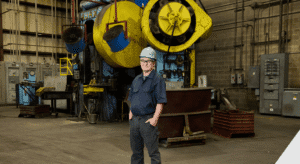 man standing in front of Ajax forging press
