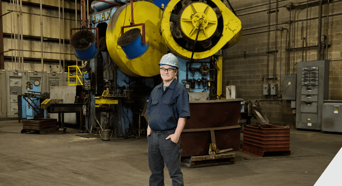 man standing in front of Ajax forging press